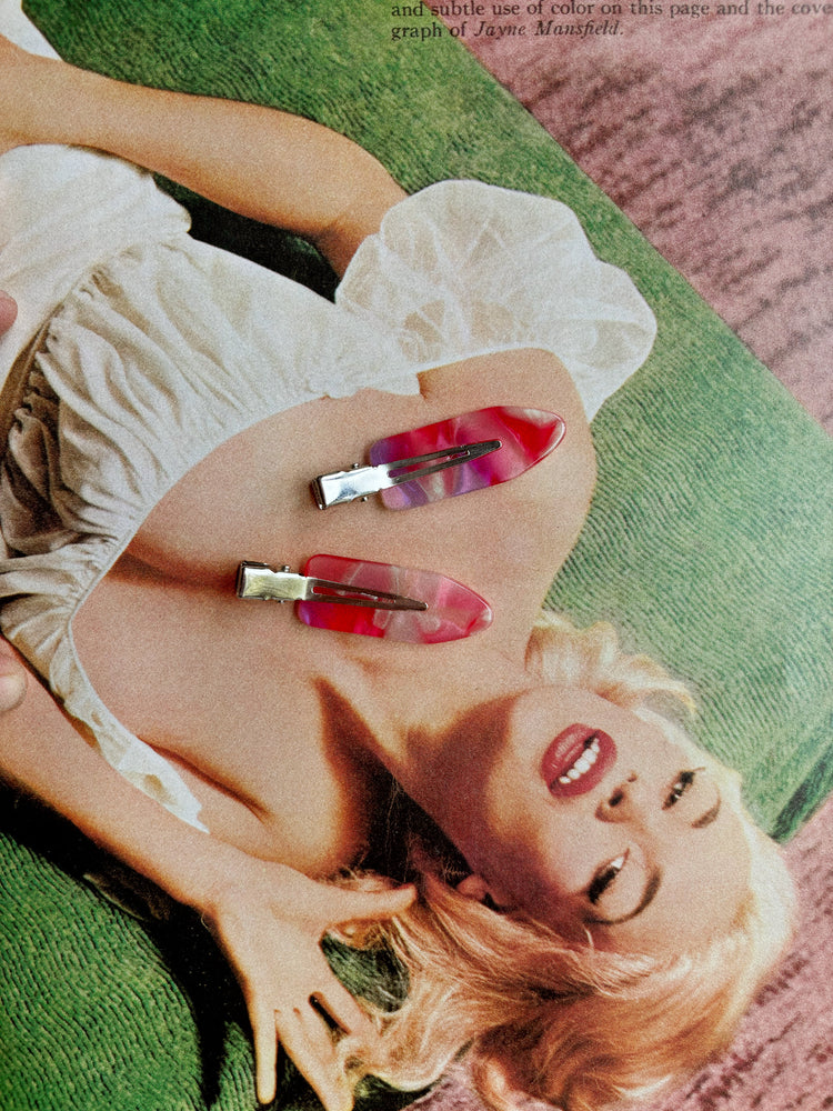 Woman lying on a green couch with red and gold hair clips in her hair, surrounded by text.